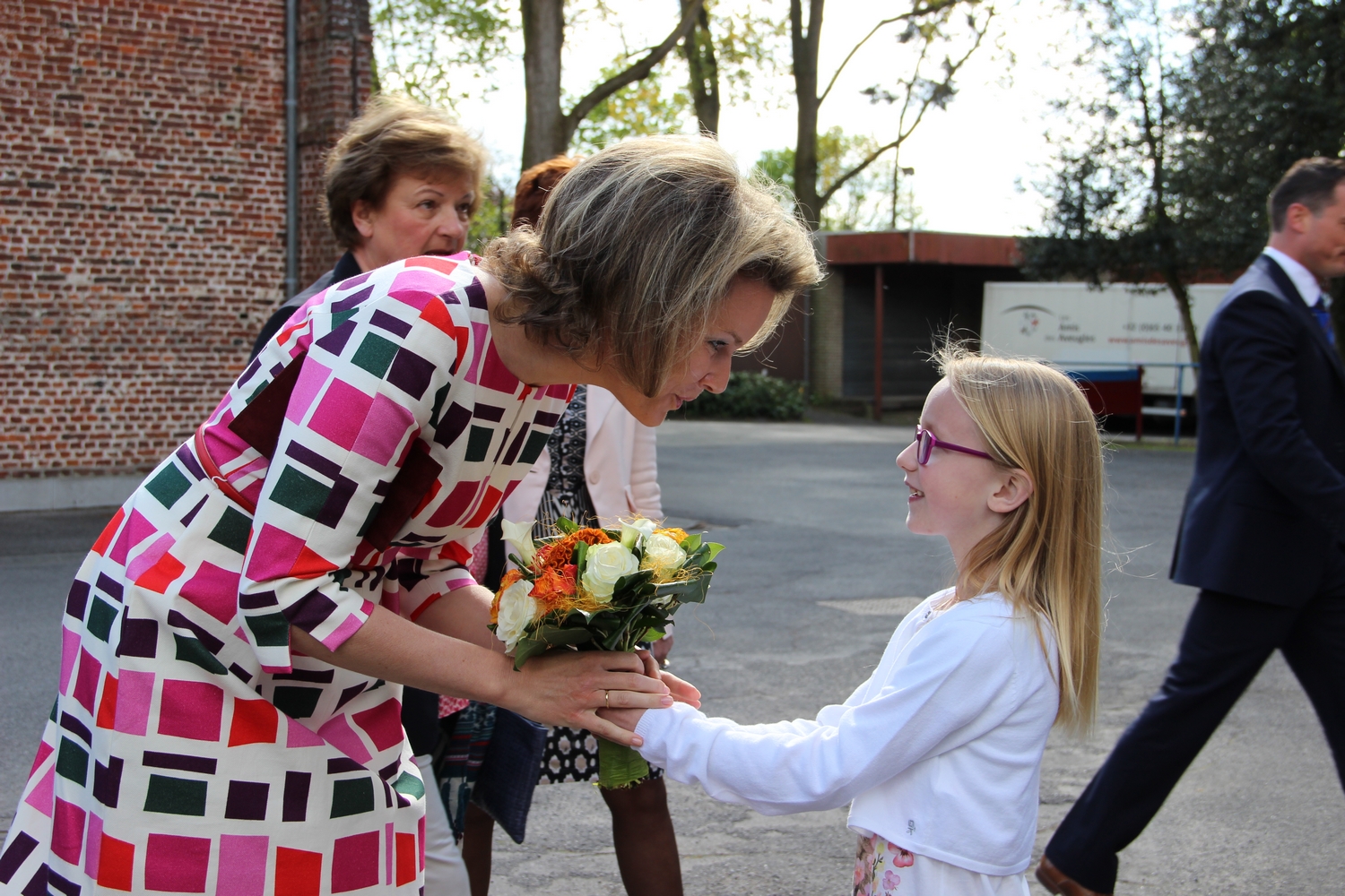 La Reine Mathilde reçoit un bouquet de fleurs de Briséis, jeune malvoyante